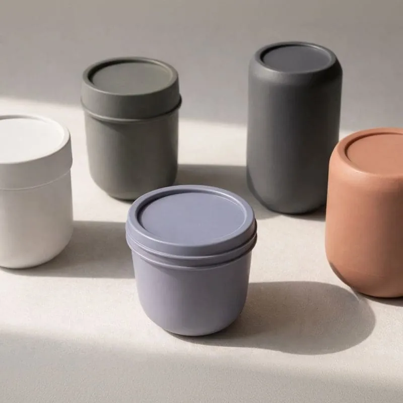 Five small containers with lids in different colours.