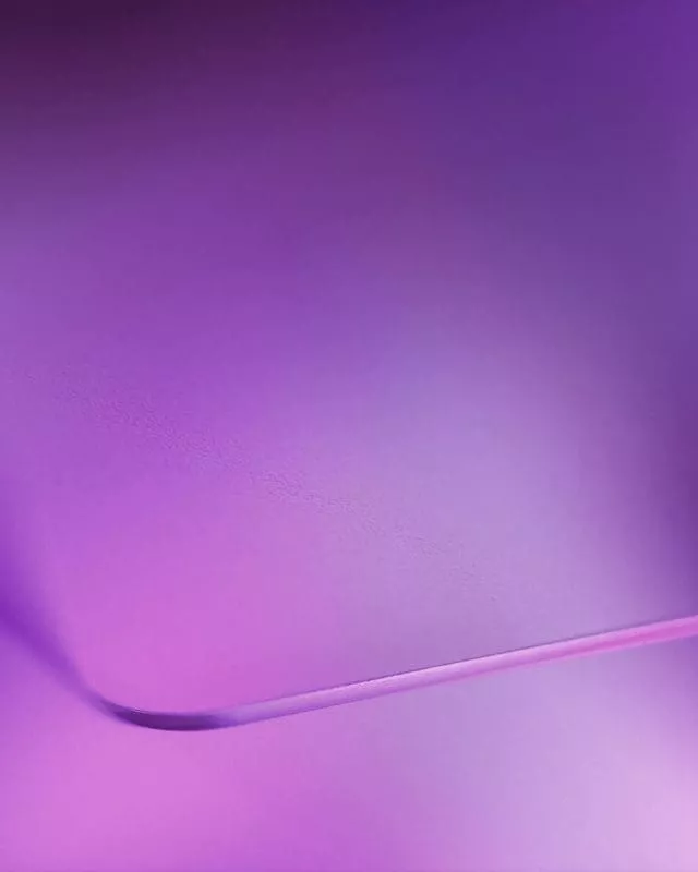 Abstract purple gradient background with a smooth curved shape.